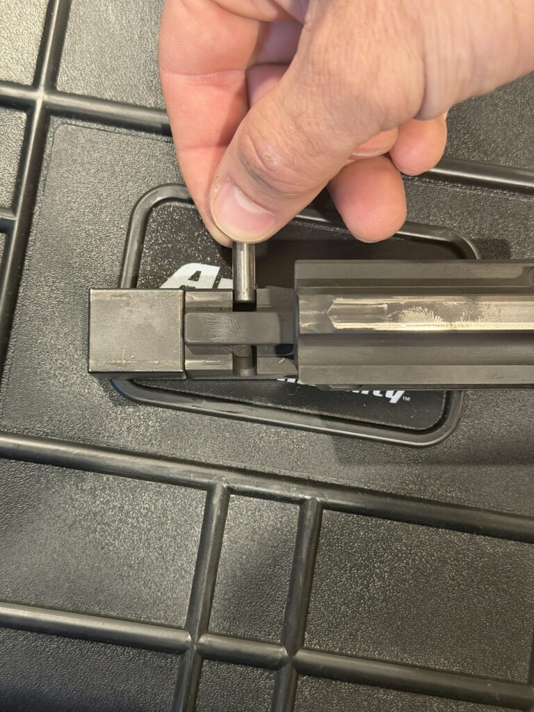 Pulling the pin out of the Stribog bolt group to free the locking block